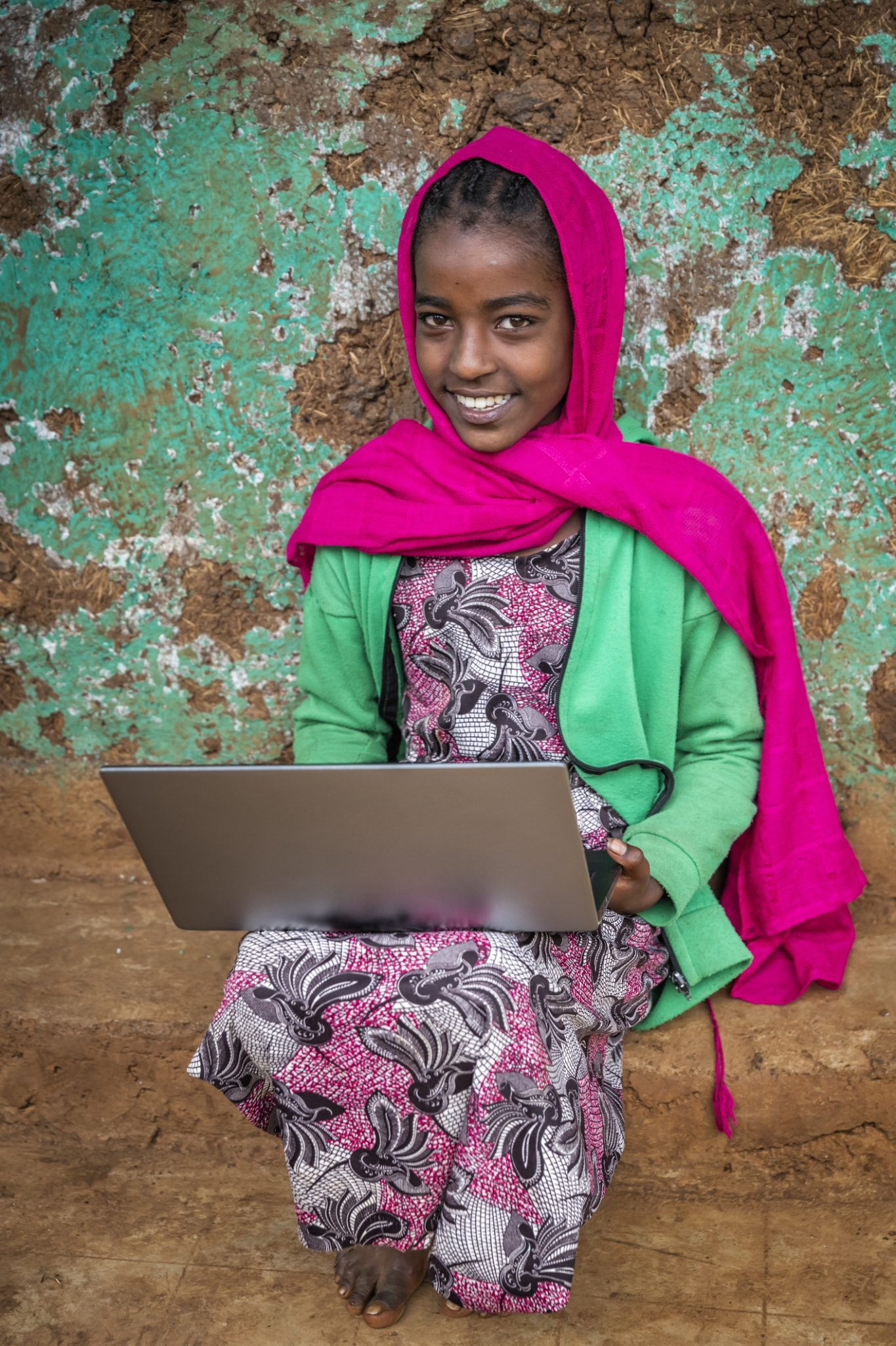 Young African girl using laptop in the village in Central Ethiopia, Africa.